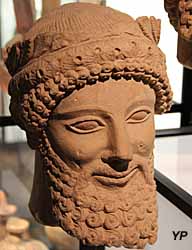 Musée de la Castre - tête barbue avec couronne de feuilles et de fleurs de narcisses en bouton, pierre calcaire (Chypre, 1ere moitié du 5e s. av. JC)